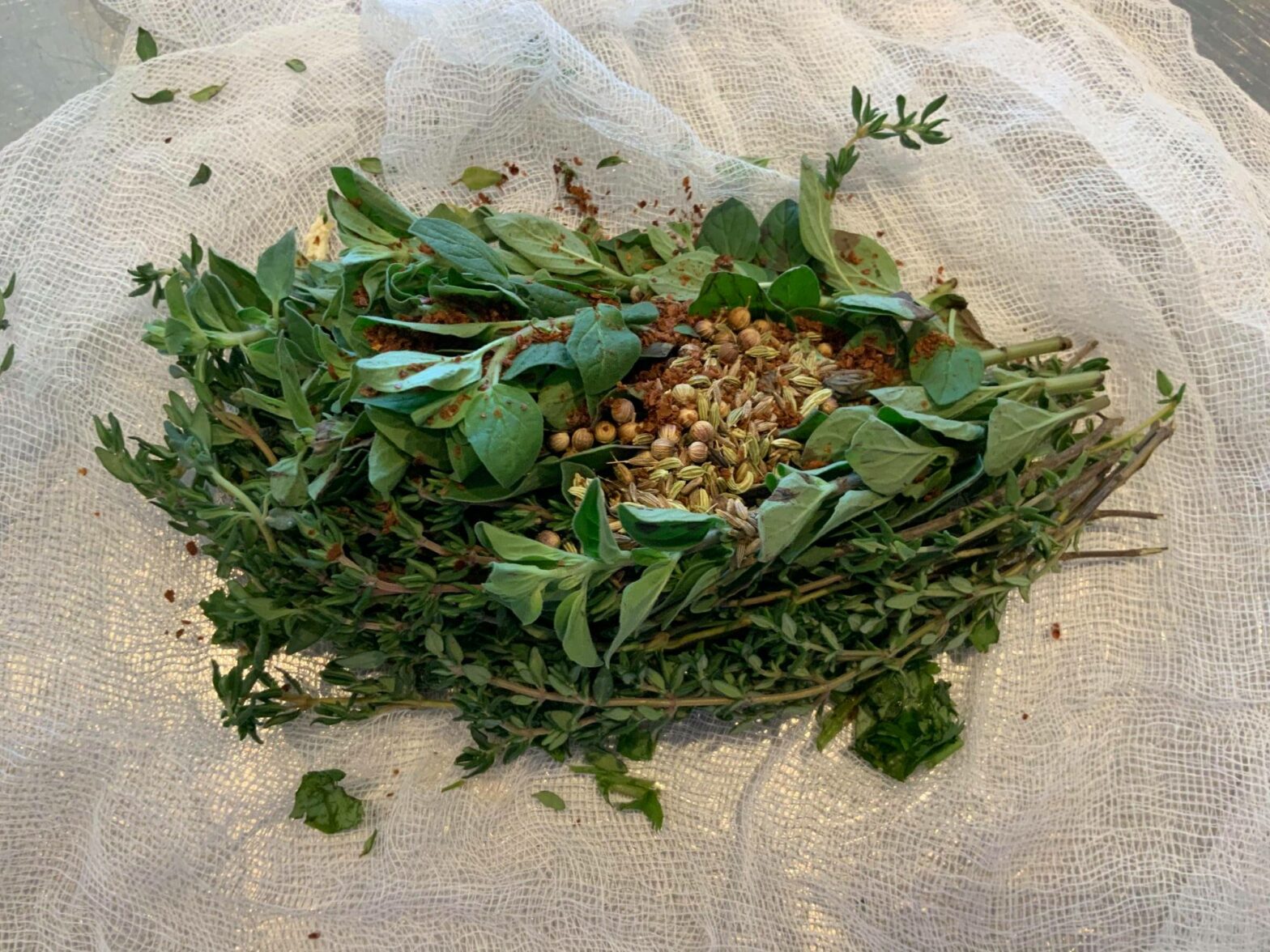 green herbs and roasted spices sit on cheesecloth